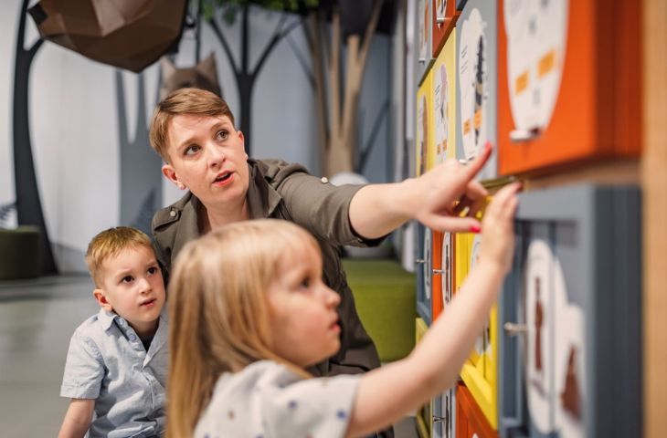 A teacher mentoring young children at a children's museum.